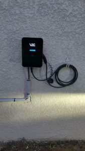 Borne de recharge V2C 7.4 kW installée sur un mur extérieur avec câble de recharge 5M attaché